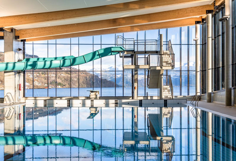 Svømmebasseng med stupetårn og utsikt mot fjorden. Foto