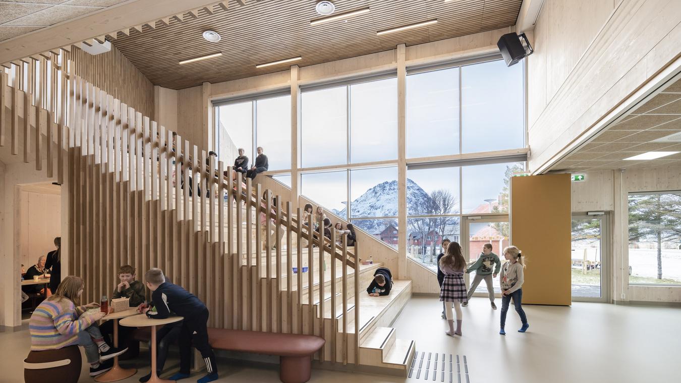 Amfitrapp i tre inne i skolebygget. Store vindusflater med utsikt over nordlandsk landskap. Foto