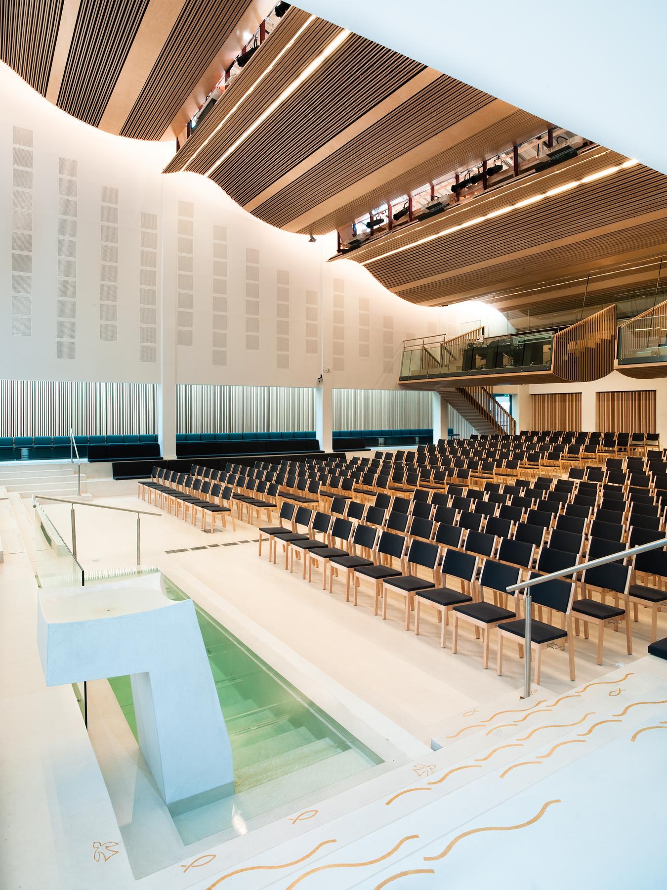 Baptismal pool in light stone with arched roof and interior in wood. Photo