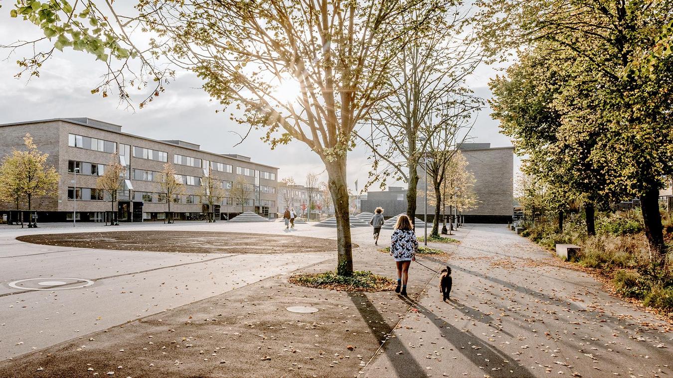 barn som går i parken og husene som ligger i bakgrunnen