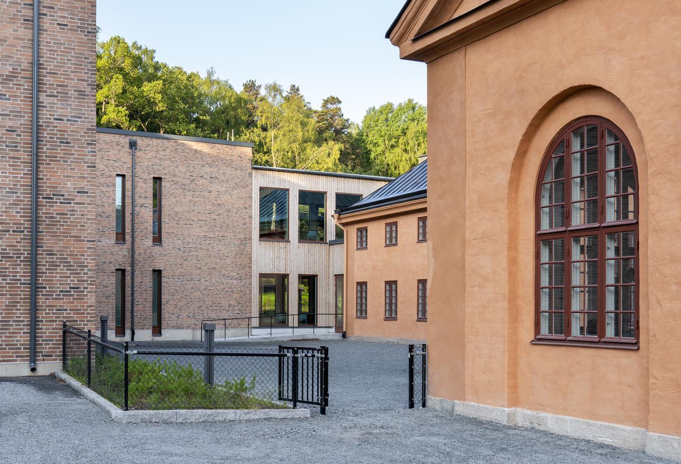 Forskellige arkitektoniske udtryk på facaden. Tegl, træ og murværk. Foto