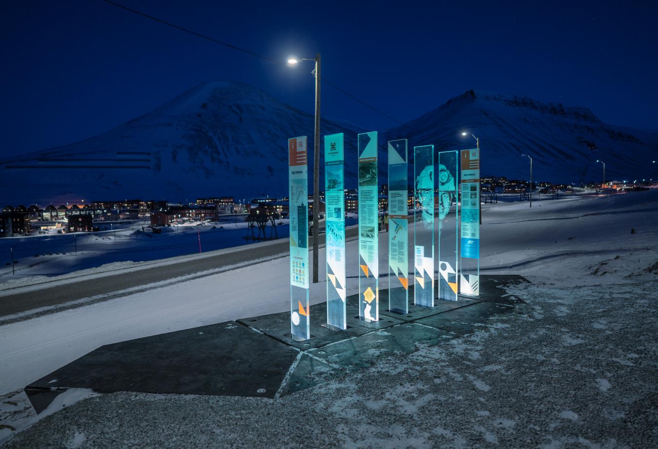 skiltstasjoner med motiver fra Svalbard på svart bakgrunn